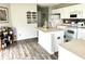 Well-lit kitchen features a white island and cabinets and dark wood-like flooring at 9873 Blue Ridge Way, Indianapolis, IN 46234