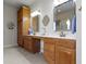 Well-lit bathroom features a double sink vanity with honey-toned wood cabinets and a white countertop at 10471 Meadow Lake Dr, Fishers, IN 46038