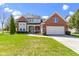 Charming two-story brick home with a two-car garage, well-maintained lawn, and neatly trimmed shrubs at 10471 Meadow Lake Dr, Fishers, IN 46038