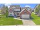 Beautiful two-story brick home with a well-manicured lawn, driveway, and attached two-car garage at 10471 Meadow Lake Dr, Fishers, IN 46038