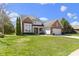 A two-story red brick home featuring a well-manicured lawn, two-car garage, and attractive landscaping at 10471 Meadow Lake Dr, Fishers, IN 46038