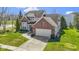 A brick two-story home featuring a two-car garage, manicured lawn, and a neatly paved driveway at 10471 Meadow Lake Dr, Fishers, IN 46038