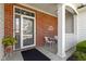 Inviting front porch with brick accents, white columns, and a cozy seating area at 10471 Meadow Lake Dr, Fishers, IN 46038