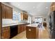 Bright kitchen boasts wood cabinets, island, stainless steel fridge, white countertops and hardwood floors at 10471 Meadow Lake Dr, Fishers, IN 46038