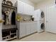 Bright laundry room with stacked washer and dryer, cabinets, and convenient coat rack with bench at 10471 Meadow Lake Dr, Fishers, IN 46038