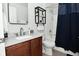 Bathroom featuring modern vanity with white countertop, wood cabinets, toilet and shower with blue curtain at 1053 Reserve Way, Indianapolis, IN 46220