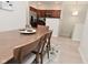 Dining area with wooden table and chairs, accented by an area rug and view to stainless steel kitchen at 1053 Reserve Way, Indianapolis, IN 46220