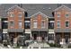 Brick townhouse with peaked roofs, multiple windows, and a black wrought iron fence at 1053 Reserve Way, Indianapolis, IN 46220