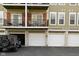 Townhome exterior featuring garages with easy access to units and a sleek SUV parked nearby at 1053 Reserve Way, Indianapolis, IN 46220