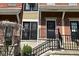 Exterior view of red brick townhouses with black doors and black wrought iron railings on concrete steps at 1053 Reserve Way, Indianapolis, IN 46220