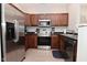 Stainless steel refrigerator and appliances are paired with rich wood cabinets and a dark countertop at 1053 Reserve Way, Indianapolis, IN 46220