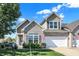 Charming two-story home features a brick facade, attached garage, and beautifully landscaped front yard on a sunny day at 10955 Chapel Woods N Blvd, Noblesville, IN 46060
