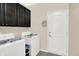 Functional laundry room with modern washer and dryer, featuring ample storage space in dark cabinets, and utility access at 10955 Chapel Woods N Blvd, Noblesville, IN 46060