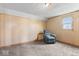 Carpeted bedroom featuring wood-paneled walls, a window, and a comfortable-looking recliner at 1126 N Anderson St, Elwood, IN 46036