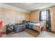 A bedroom featuring wood paneling, carpeted floors, and a comfortable recliner near the bed at 1126 N Anderson St, Elwood, IN 46036