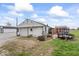 Exterior view of garage and shed, situated in a large yard on a partly cloudy day at 1126 N Anderson St, Elwood, IN 46036