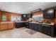 Kitchen with wood paneling, black cabinets, vinyl flooring and two toned cabinets at 1126 N Anderson St, Elwood, IN 46036