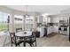 Sunlit kitchen and dining nook featuring white cabinets, stainless appliances, and modern finishes at 12258 Weathered Edge Dr, Fishers, IN 46037