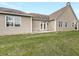 House backyard with green lawn and attached patio with dual doors leading to the house at 12521 Hawks Landing Dr, Fishers, IN 46037