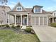 Charming two-story home with a brick and siding facade, covered porch, and well-maintained landscaping at 12521 Hawks Landing Dr, Fishers, IN 46037