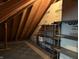 This is an attic space with wood rafters, paneling and metal shelving at 1304 Park Meadow Dr, Beech Grove, IN 46107