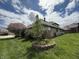 Landscaped backyard with flowering trees and a charming stone-bordered garden at 1304 Park Meadow Dr, Beech Grove, IN 46107