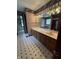 Bathroom featuring double sinks, tile floors, and decorative wallpaper at 1304 Park Meadow Dr, Beech Grove, IN 46107