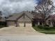 A brick home with a three car garage and mature trees at 1304 Park Meadow Dr, Beech Grove, IN 46107