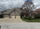 A brick home with a three car garage and mature trees at 1304 Park Meadow Dr, Beech Grove, IN 46107