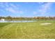 Scenic backyard view of the lake with a fountain and vibrant green lawn at 1416 Gleneagle Dr, Indianapolis, IN 46239