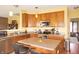 Bright kitchen features stainless appliances, central island with bar stools, and honey colored cabinetry at 1416 Gleneagle Dr, Indianapolis, IN 46239