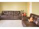 Spacious living room features leather couches, neutral paint, and natural lighting at 1416 Gleneagle Dr, Indianapolis, IN 46239