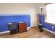 This vacant room has blue wainscoting, light-colored walls, and wood flooring at 1416 Gleneagle Dr, Indianapolis, IN 46239