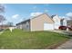 Enjoy this well-maintained backyard space with a detached garage, a red car and green grass at 14226 Marilyn Rd, Noblesville, IN 46060