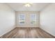 Bedroom with wood-look floors, ceiling fan, and natural light through the two windows at 14226 Marilyn Rd, Noblesville, IN 46060