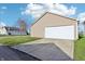 View of detached two car garage with wide driveway and well-manicured lawn on a bright and sunny day at 14226 Marilyn Rd, Noblesville, IN 46060