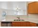 View of kitchen with stainless appliances, wood cabinets, and white countertops overlooking living room at 14226 Marilyn Rd, Noblesville, IN 46060