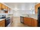 View of kitchen with stainless appliances, wood cabinets and white countertops with easy access to living room at 14226 Marilyn Rd, Noblesville, IN 46060