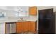 Eat-in kitchen features stainless dishwasher, wood cabinets and view into living area at 14226 Marilyn Rd, Noblesville, IN 46060