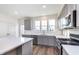 Modern kitchen featuring stainless steel appliances, an island, gray cabinets and a view of the neighborhood at 14538 Hanford Ln, Carmel, IN 46074
