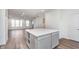 Open concept living space features an island with storage, wood floors, and a staircase at 14538 Hanford Ln, Carmel, IN 46074