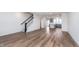 Open-concept living room featuring wood-look flooring, white walls, and staircase to the next level at 14538 Hanford Ln, Carmel, IN 46074