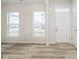 Inviting living room with wood-look floors, windows, and a bright white front door at 14538 Hanford Ln, Carmel, IN 46074