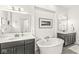 This bathroom features a soaking tub, patterned floor, and double vanity with a white countertop and dark cabinets at 1501 Chanson Ln, Westfield, IN 46074
