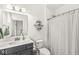 Bright bathroom with a dark vanity, white countertop, decorative shelves, and shower with patterned curtain at 1501 Chanson Ln, Westfield, IN 46074