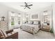Bright primary bedroom with ceiling fan, large windows and hardwood dresser at 1501 Chanson Ln, Westfield, IN 46074