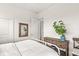 Neutral bedroom with white bed, a wooden-framed mirror and dresser adorned with a plant for a touch of nature at 1501 Chanson Ln, Westfield, IN 46074