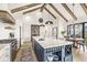 Open kitchen features an island with marble countertops, wine rack and wood beam vaulted ceilings at 1501 Chanson Ln, Westfield, IN 46074
