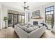Bright living room with fireplace, large windows, ceiling fan and light gray sectional sofa at 1501 Chanson Ln, Westfield, IN 46074