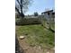 Backyard with blooming dandelions and wooden fence surrounding the property at 1623 S Grant Ave, Indianapolis, IN 46203